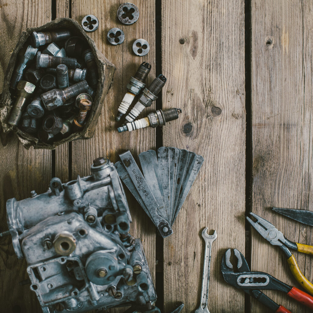 Carburetors for a car engine with tools on wooden table